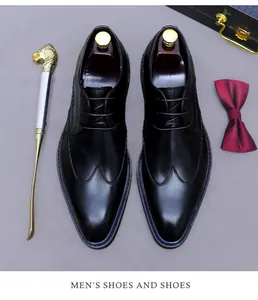 Dettaglio di scarpe Oxford nere wingtip con texture in pelle, papillon e calzante