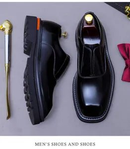 Detail von glänzenden Leder-Loafers mit quadratischer Zehenpartie und orangefarbenem Akzent
