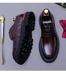 Derbies en cuir marron avec semelles noires épaisses et détails orange au talon