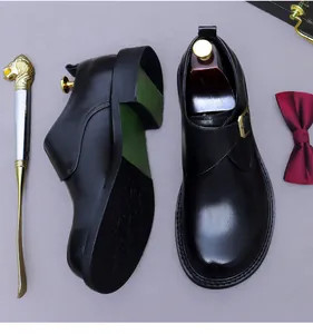 Vue détaillée de chaussure monk noire en cuir avec boucle dorée et semelle verte