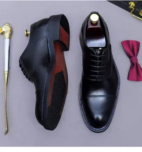 Draufsicht auf Premium Leder-Oxford-Schuhe mit roter Sohle und Business-Accessoires