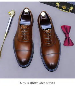 Nahaufnahme brauner Cap-Toe-Oxford-Schuhe aus Leder mit Farbverlauf und Accessoires