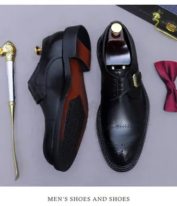 Detail eines schwarzen Leder-Monkschuhs mit Brogue-Verzierung und goldener Schnalle