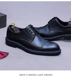 Detailaufnahme schwarzer Business-Lederschuhe mit blauer Naht und Blattstickerei-Motiv