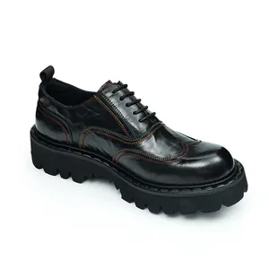 Detail of black leather oxford shoe featuring vibrant contrast stitching and a platform sole
