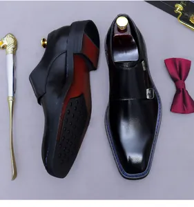Dettaglio di scarpe monk strap doppie in pelle nera con fibbie d'argento e suola gommata