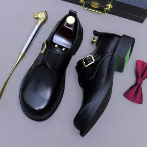 Chaussure monk en cuir noir poli avec boucle dorée dans un style gentleman britannique chic