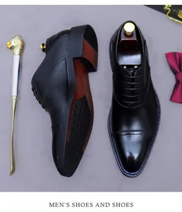Polished black leather cap toe oxfords with textured non-slip sole and golden shoehorn