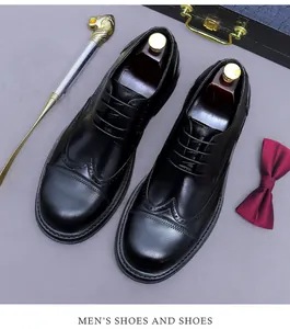 Nahaufnahme schwarzer Brogue-Lederschuhe mit dekorativen Schuhspannern und Luxus-Box