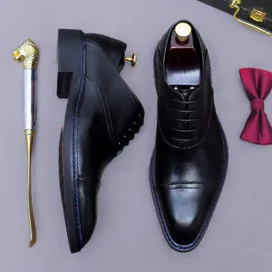 Classic black leather oxford shoes with blue stitching and business accessories