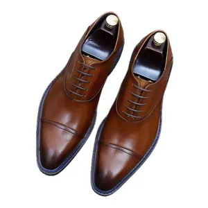 Classic brown cap-toe leather oxfords for men with vintage gradient finish on white background