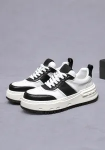 Λεπτομέρεια από ασπρόμαυρα δερμάτινα sneakers με χοντρές σόλες πλατφόρμας και αντιολισθητικό