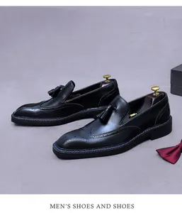Détail de mocassins en cuir noir avec glands, motifs richelieu et couture de semelle bleue