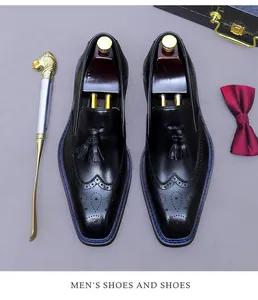 Vue de dessus des mocassins brogues en cuir noir avec glands et accessoires de luxe