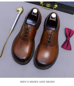 Top view of brown leather brogue shoes with decorative perforation and elegant accessories