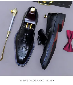 Détail de mocassin à glands en cuir noir avec coutures bleues et embauchoir en bois