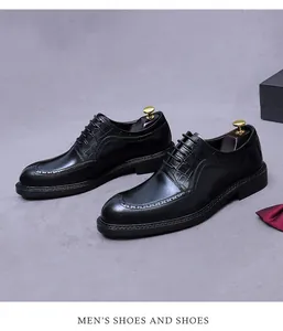 Detail of premium black leather oxfords with brogue carving and crocodile embossed patterns