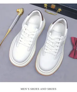 Dettaglio di sneaker da uomo in pelle bianca con tallone marrone e suola spessa