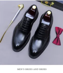 Close-up of black leather brogue shoes with wingtip detailing and luxury gift packaging