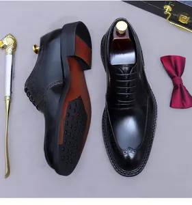 Detail of black leather brogue shoes with intricate wingtip carving and non-slip sole