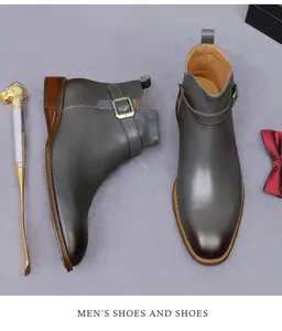 Close-up of grey leather boots with decorative side buckle and lion head shoehorn