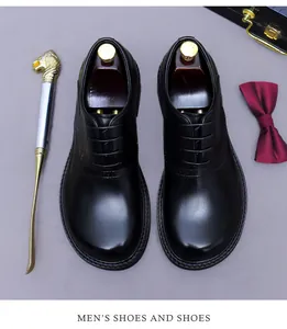 Top view of black leather Oxford shoes with refined brogue detailing and wooden shoe trees