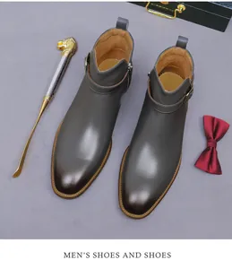 Top view of leather dress boots with buckle detail and zip next to formal accessories