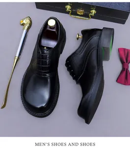 Detail shot of black leather Brogue shoes with gold shoehorn and luxury accessories