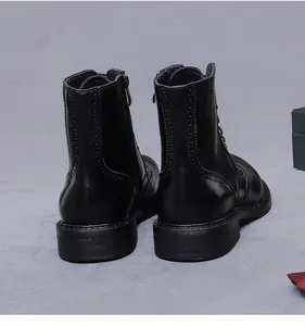 Dettaglio delle decorazioni Brogue sugli stivali in pelle nera con cerniera laterale