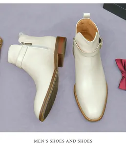 Top-down view of cream leather men's dress boots with side zipper and buckle detail