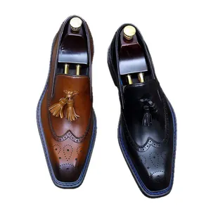 Vue de dessus des mocassins en cuir pour hommes avec motifs brogue et glands brun et noir