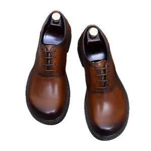Men's brown gradient leather oxford shoes with brogue carving on a white background
