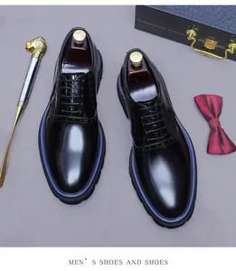 Close-up of black polished brogue shoes with unique blue stitching and luxury accessories