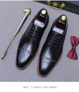 Men's black leather oxford shoes with rivets, shoe horn and bow tie flat lay view