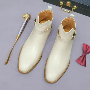 Beige leather men boots with buckle and side zipper shown in a luxury setting