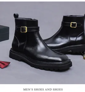 Detalle de bota de cuero negro con hebilla de metal dorado y suela gruesa de goma