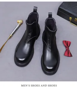 Gros plan de bottines Chelsea en cuir noir avec empiècements élastiques sur fond gris