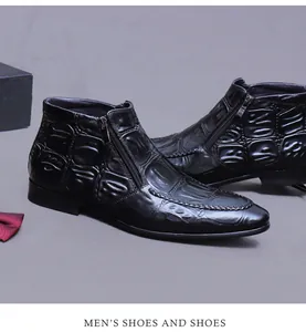 Detail of black embossed leather ankle boots with side zipper and pointed toe style