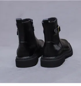 Vista trasera de botas de cuero negro con hebilla metálica y suela de goma duradera