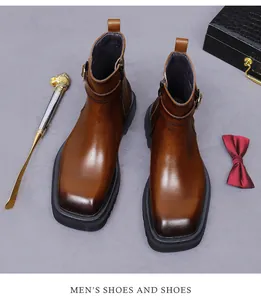 Detalle de botas de cuero marrón con hebilla metálica y cremallera lateral