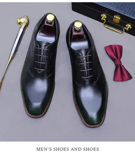Detalle de oxfords verde oscuro con grabado artesanal y accesorio calzador de cabeza de león