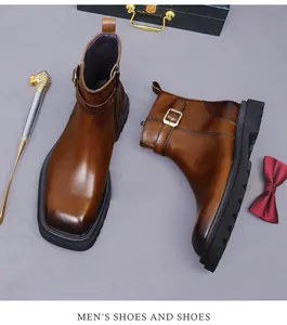 Detalle de botas de cuero marrón con hebillas metálicas y cetro de cabeza de león