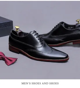 Détail de chaussures brogues en cuir noir avec liseré rouge et perforations bout fleuri