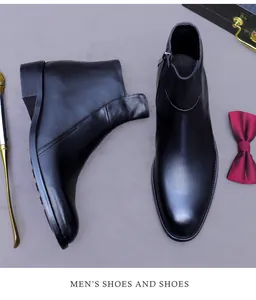 Heren Chelsea boots van zwart leer met rits, getoond met schoenlepel en vlinderdas