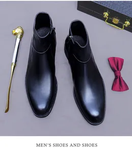 Bovenaanzicht van zwarte leren Chelsea boots met rits en luxe herenaccessoires in beeld