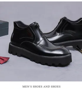 Detail of glossy black leather boots with front zipper and brogue decorative perforations