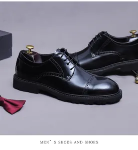 Detail of classic black brogue leather shoes with elegant wooden shoe trees on a grey background