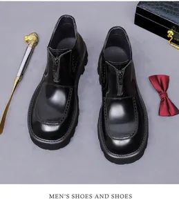 Close-up of black glossy leather boots with front zipper and thick lugged sole