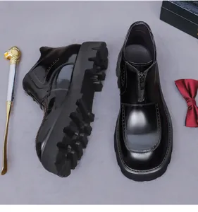 Detail of glossy black leather platform boots with front zipper and serrated thick sole