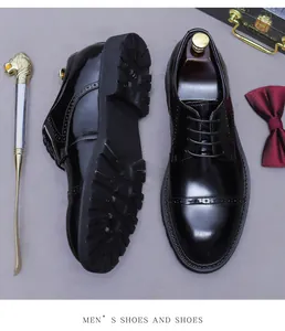 Detail of black glossy leather brogue shoes with lug sole and classic wingtip engraving